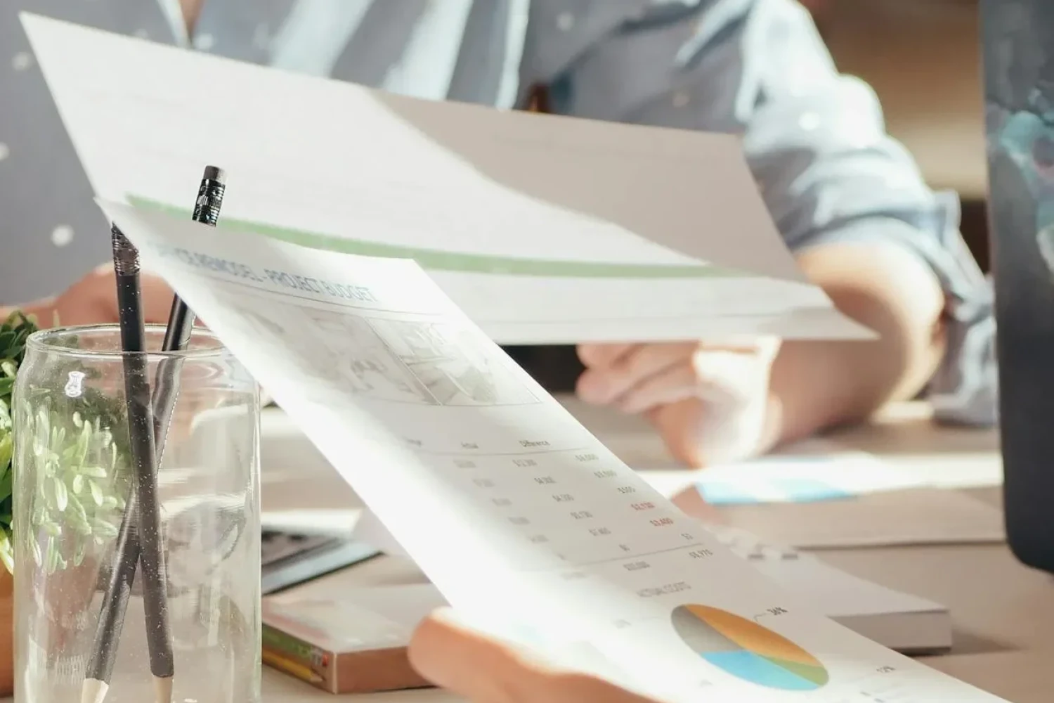 Person analysiert LMS Kosten und Budgetplanung – Was kostet ein Lernmanagementsystem für Unternehmen