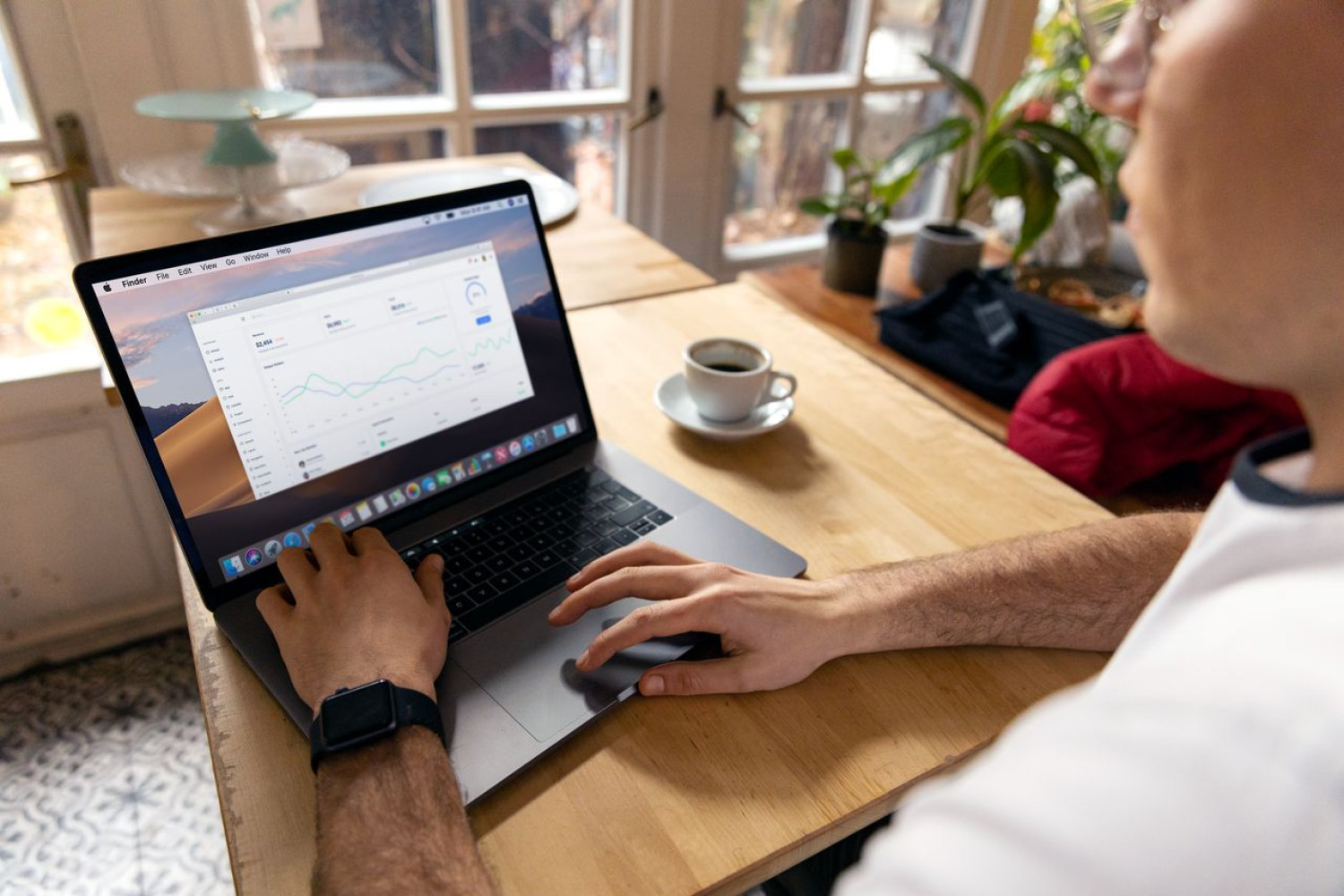 Person arbeitet mit Laptop und Analytics-Dashboard am Schreibtisch – SCORM oder xAPI