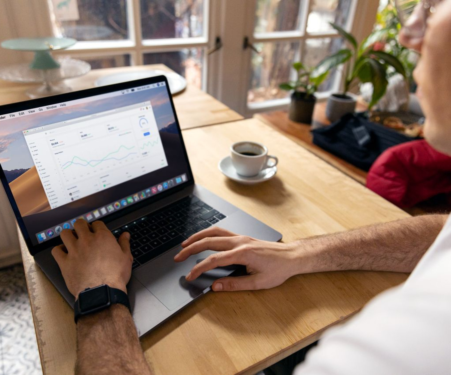 Person arbeitet mit Laptop und Analytics-Dashboard am Schreibtisch – SCORM oder xAPI