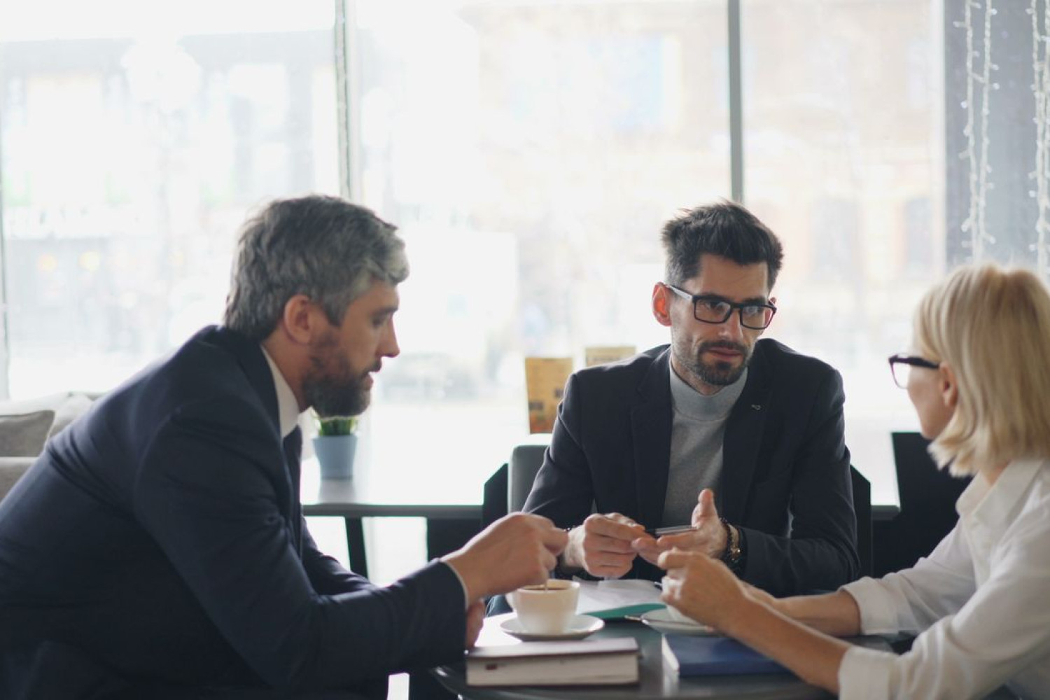 Drei Personen im Beratungsgespräch am Tisch – gemeinsame Entscheidungsfindung bei der LMS-Auswahl