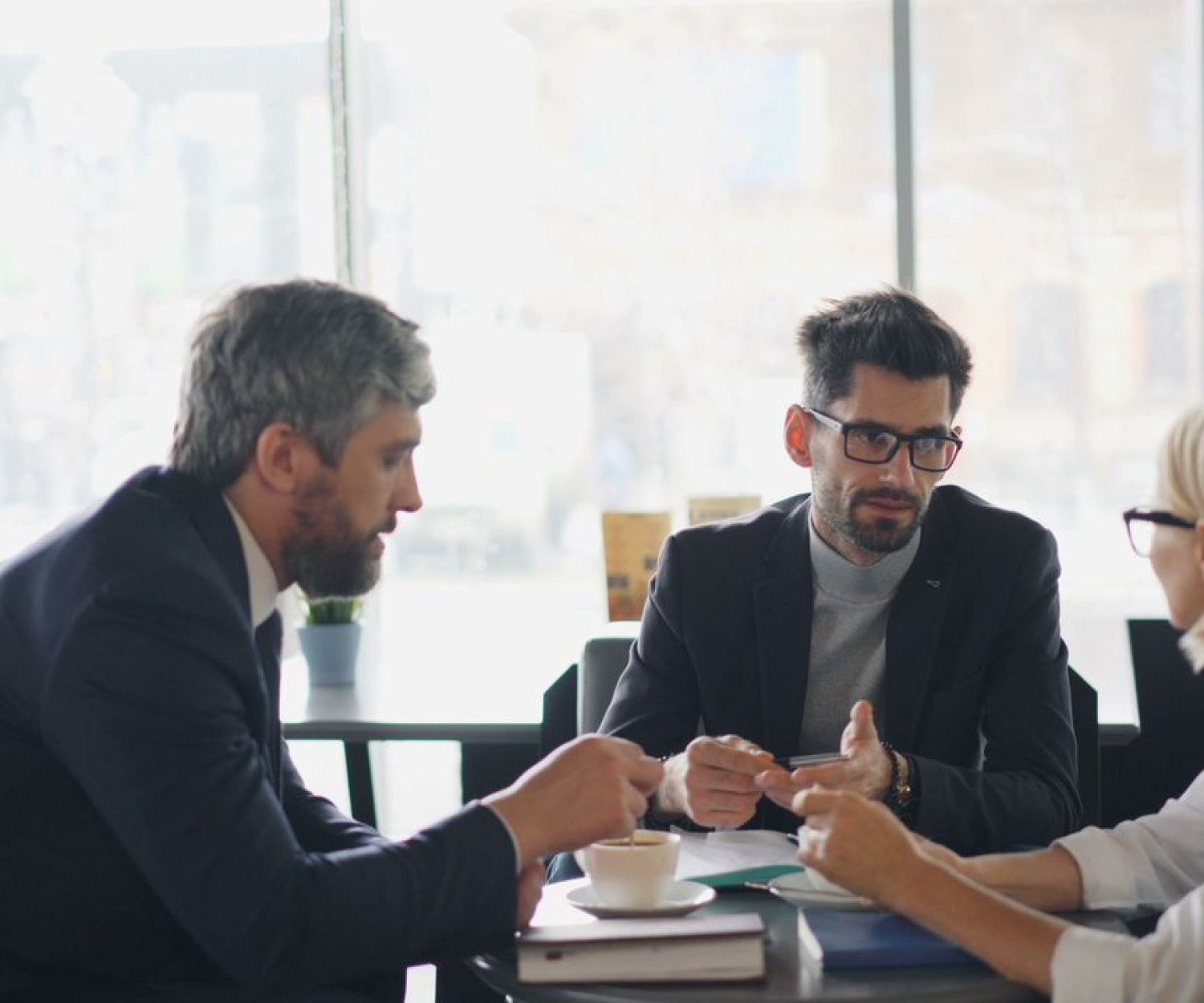 Drei Personen im Beratungsgespräch am Tisch – gemeinsame Entscheidungsfindung bei der LMS-Auswahl
